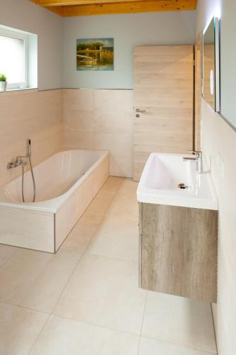 a white bathroom with a tub and a sink at Ferienhaus Jonas in Rieden