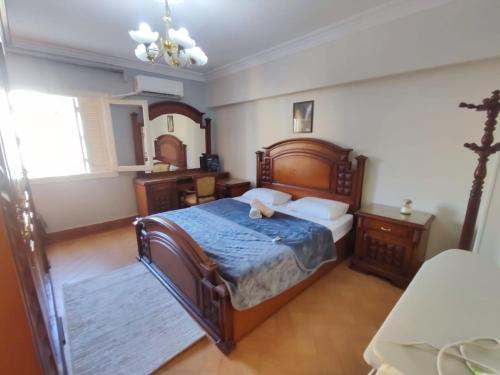 a bedroom with a large wooden bed with a blue blanket at Where landsacpe view meets Luxury in Cairo