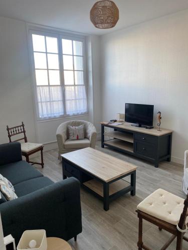 a living room with a couch and a tv at Appartement sur le port du Pouliguen in Le Pouliguen