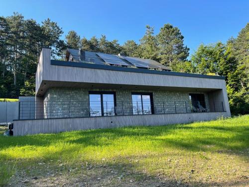 a house on a hill with trees in the background at Point de Vue Caleste in Wellin