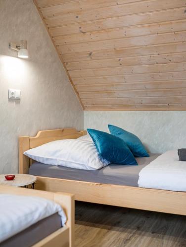 a bedroom with two beds and a wooden ceiling at Domki Irena Kozdrowska in Polańczyk