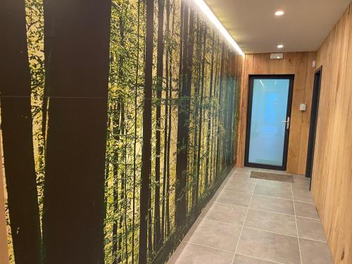 a hallway with a wall mural of trees at Point de Vue Caleste in Wellin