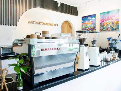 a coffee shop with a counter with a machine at Pendhapa Art Space - PAS Limasan Homestay in Yogyakarta