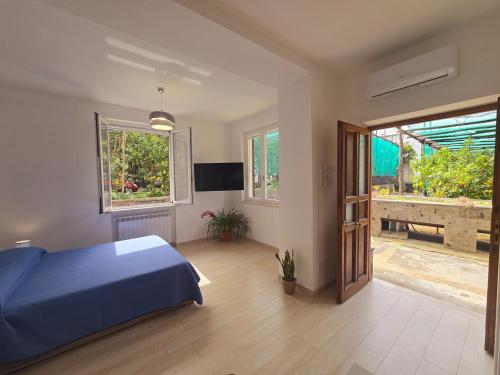 a bedroom with a blue bed and a sliding glass door at The house in the green in Piano di Sorrento