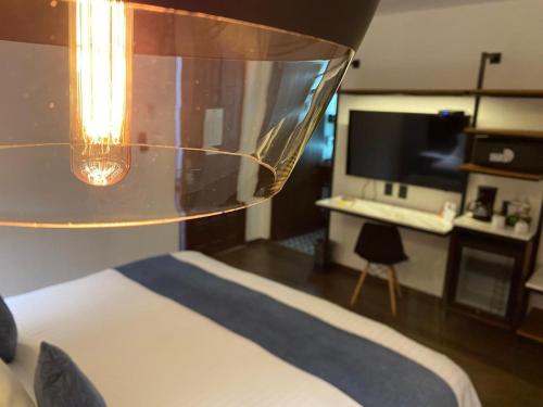 a bedroom with a bed and a desk with a television at Hotel Boutique Casa Loreta in Querétaro