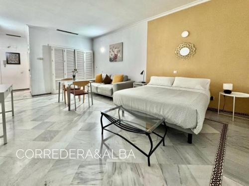 sypialnia z łóżkiem i salonem w obiekcie Habitaciones Casa Sevillana Centro w Sewilli