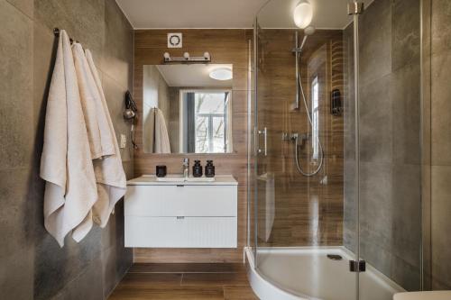a bathroom with a tub and a sink and a shower at Alpari Wawel in Kraków