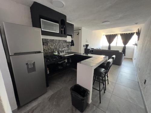 a kitchen with a refrigerator and a table with chairs at departamento familiar centrico cerca de playa y plazas comerciales con wifi 200 in Puerto Vallarta