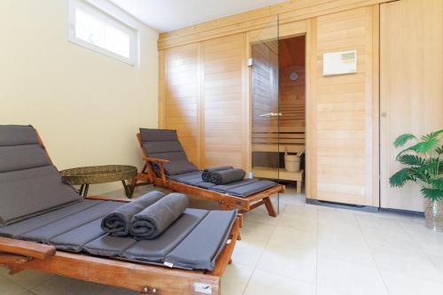 a room with two lounge chairs and a bathroom at Luxury Villa with Indoor Pool, Jacuzzi, Sauna & Breathtaking City View in Klosterneuburg