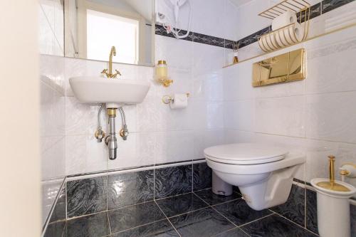 a white bathroom with a sink and a toilet at Luxury Villa with Indoor Pool, Jacuzzi, Sauna & Breathtaking City View in Klosterneuburg