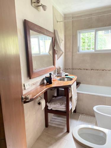 a bathroom with a sink and a toilet and a mirror at Casa taller in Tigre