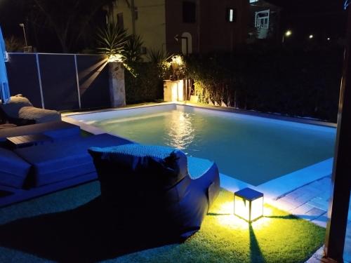 a swimming pool at night with a couch and lights at Luxury Villas Chrysa Private Pool & Spa in Nafplio