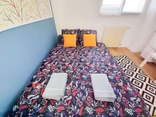 - un lit avec deux oreillers orange dans l'établissement Le Cosy - studio proche basilique saint Rémi, à Reims