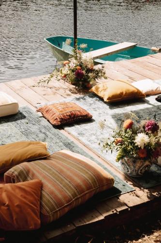 a wooden dock with pillows and a boat on the water at Castello in Lucignano