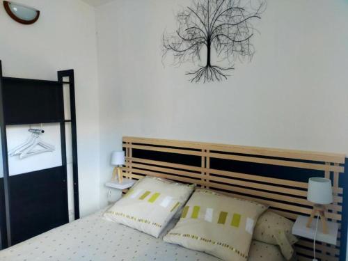 - une chambre avec un lit et un arbre sur le mur dans l'établissement Maison avec courette à 400 m de la plage, à La Bernerie-en-Retz