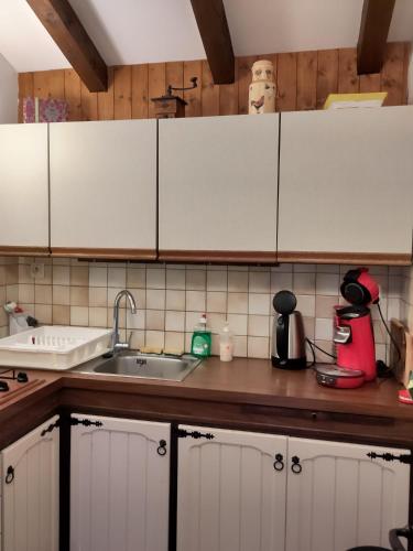 une cuisine avec des armoires blanches et un évier dans l'établissement Grand appartement 6 personnes, à Crest-Voland