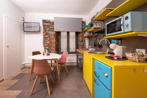 a kitchen with a small table and a yellow kitchen at Baby Art Apartment in Arona