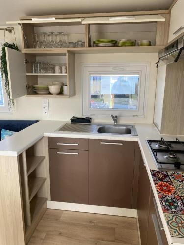 une cuisine avec un évier et une fenêtre dans l'établissement Les pieds dans l eau, à Le Portel