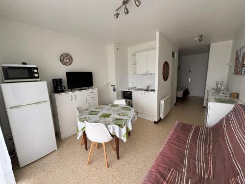 une cuisine avec une table et une petite cuisine avec une cuisine dans l'établissement Appartement avec balcon, animaux admis, proche Thermes - FR-1-503-81, à Balaruc-les-Bains