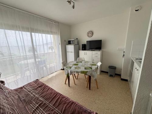 une chambre avec une table et une cuisine avec une fenêtre dans l'établissement Appartement avec balcon, animaux admis, proche Thermes - FR-1-503-81, à Balaruc-les-Bains