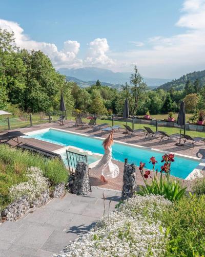 une femme est en train de courir au bord d'une piscine dans l'établissement Les Chalets de Ludran, à Viuz-en-Sallaz
