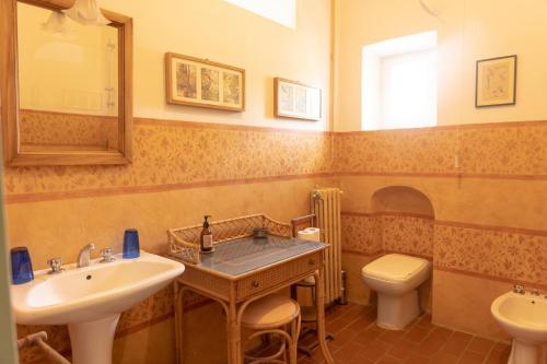 a bathroom with a sink and a toilet and a mirror at Castello in Lucignano