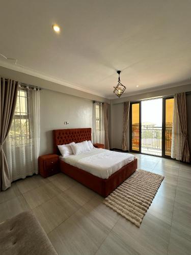 a bedroom with a large bed and a balcony at CasaComfy Bukoto in Kampala