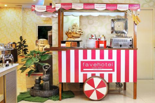 a red and white vendor cart in a kitchen at favehotel Solo Baru in Solo