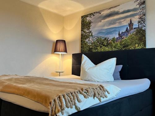 a bedroom with a bed with a painting on the wall at Harzträume No4 # Parkplatz # 2 separate SZ # Smart-TV in Wernigerode