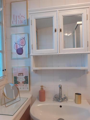 une salle de bain avec un lavabo et un meuble blanc dans l'établissement Le Logis d'Hermione, à Caden