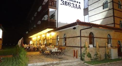 eine Gruppe von Menschen, die nachts in einem Restaurant sitzen in der Unterkunft Семеен хотел Звезда in Sŭdievo