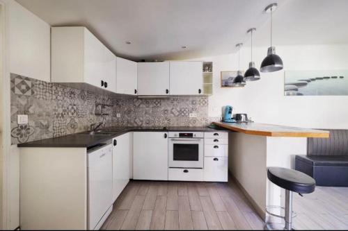 une cuisine avec des armoires blanches et un comptoir dans l'établissement Le Balcon de Sadi Carnot Plein centre historique, à La Ciotat