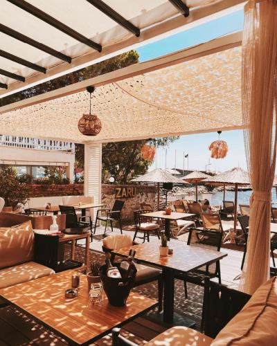 a restaurant with tables and chairs and a view of the ocean at Yalinn Boutique Hotel in Yalıkavak
