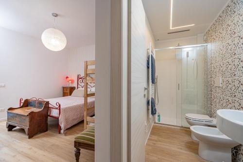 ein Badezimmer mit Waschbecken und Toilette und ein Bett in der Unterkunft La Casina Bianca in Santa Maria degli Angeli