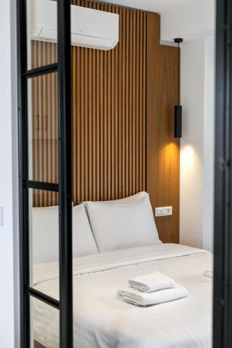 a bedroom with a bed with a wooden headboard at Athens Genesis Luxury Suites By SEM in Athens