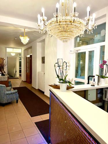 a large living room with a chandelier at Hotel zu den Linden in Wachtberg