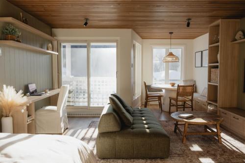 a bedroom with a couch and a table and a dining room at BÕSKI - Refuge de luxe in Stoneham