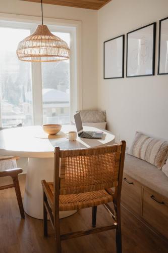 a dining room with a table with a laptop on it at BÕSKI - Refuge de luxe in Stoneham