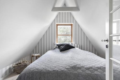 a bedroom with a bed and a window at Cozy vacation home very close to the beach in Tisvilde