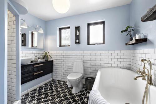 a bathroom with a tub and a toilet and a sink at Cozy vacation home very close to the beach in Tisvilde