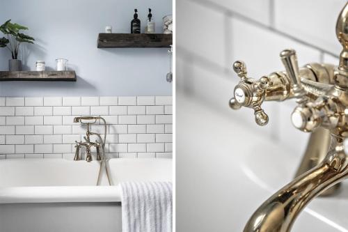 a bathroom with a gold faucet and a sink at Cozy vacation home very close to the beach in Tisvilde