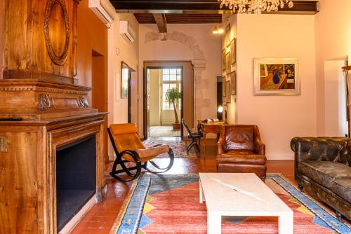 a living room filled with furniture and a fireplace at Palais Aoma, hôtel particulier de luxe en Provence in LʼIsle-sur-la-Sorgue