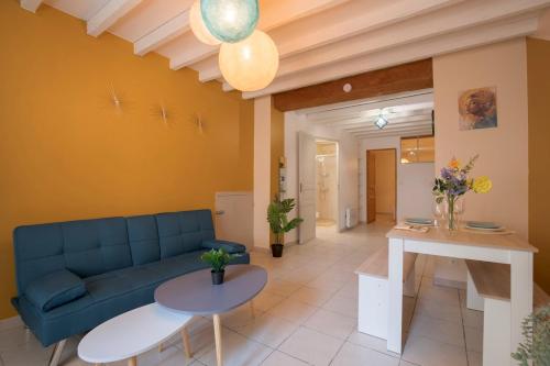 un salon avec un canapé bleu et une table dans l'établissement Le Ginger Tricastin, à Lapalud