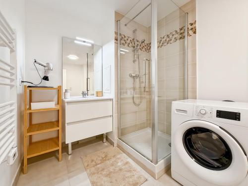 eine Waschmaschine in einem Badezimmer mit Dusche in der Unterkunft Suite Rosa Disneyland Paris - Rentaway BnB in Coupvray