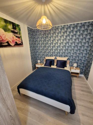 a bedroom with a large bed with a blue blanket at Bel appartement proche de Paris in Puteaux