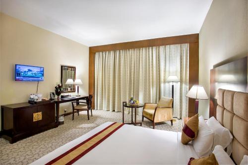 a hotel room with a bed and a desk at Rose View Hotel in Sylhet