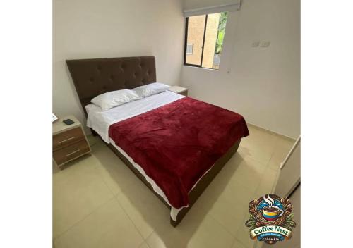 Un dormitorio con una cama grande con una manta roja. en Coffee Nest - La Tebaida - Armenia - Quindio, en La Tebaida