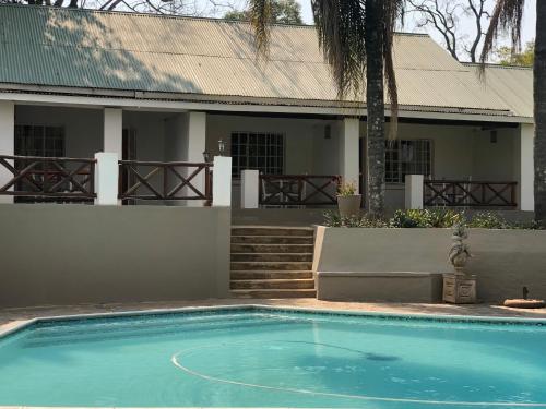 a swimming pool in front of a house at Georges Valley Lodge in Tzaneen