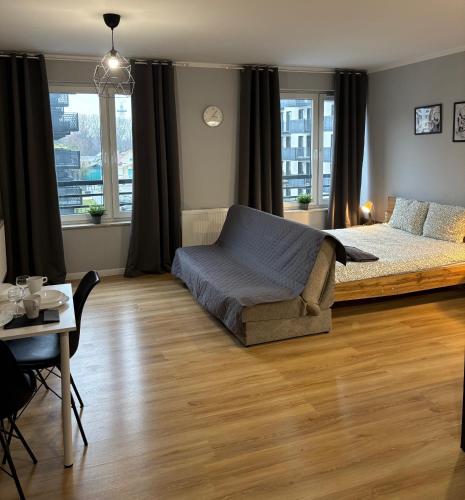 a bedroom with a bed and a table and a tableablish at Holdek Apartamenty Ceglana in Katowice
