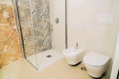 a bathroom with a shower and a toilet and a sink at Dimora Antica Falegnameria - tra STORIA e RELAX in Ostuni